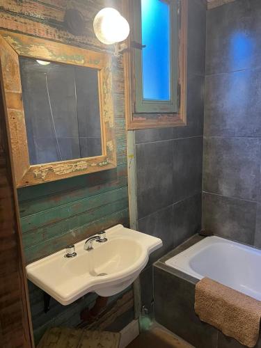 a bathroom with a sink and a bath tub at mercado NL in Villa La Angostura