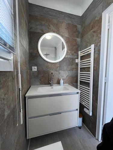 une salle de bain avec un lavabo blanc et un miroir dans l'établissement Charmante maison Canétoise proche plage et commodités !, à Canet