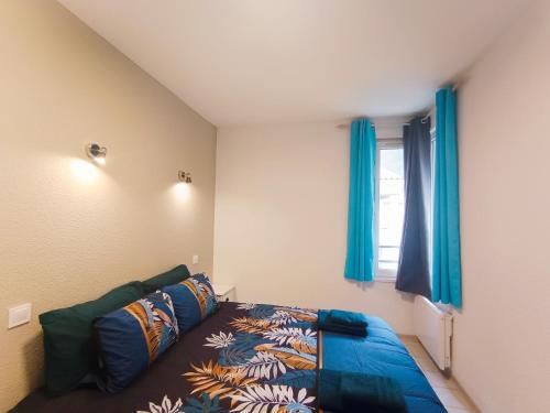 une chambre avec un lit et une fenêtre avec des rideaux bleus dans l'établissement Le nid des Bains - Climatisé - Piscine partagée, à Digne-Les-Bains