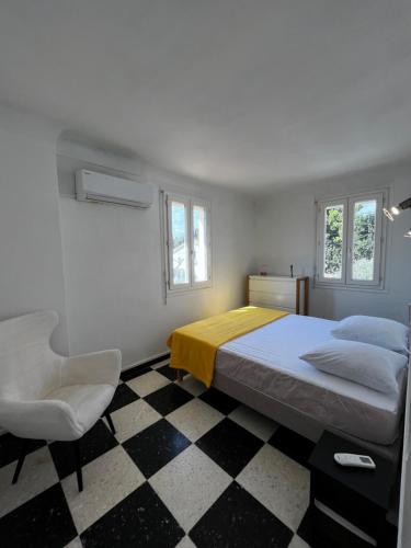 une chambre avec un lit, une chaise et des fenêtres dans l'établissement Charmante maison Canétoise proche plage et commodités !, à Canet