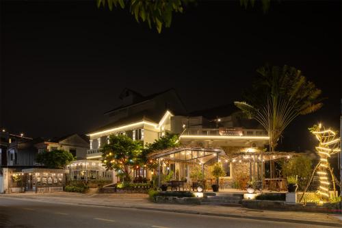 a building with christmas lights on a street at night at Goda Boutique Hotel in Hoi An