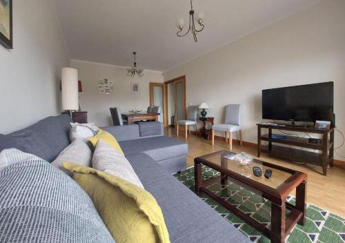 a living room with a couch and a tv at Silver Waves in Vila Nova de Gaia