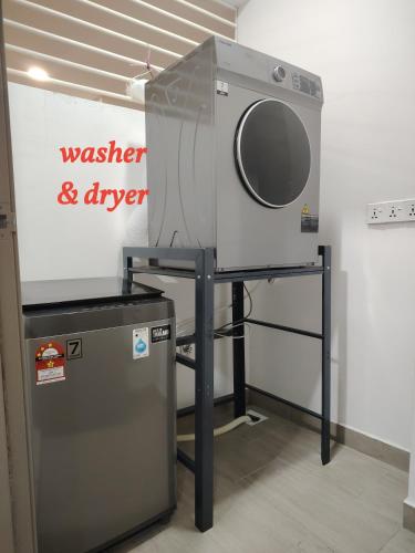 a washing machine on a stand next to a sign at Larkin bus terminal Doraemon Home by YHA in Johor Bahru