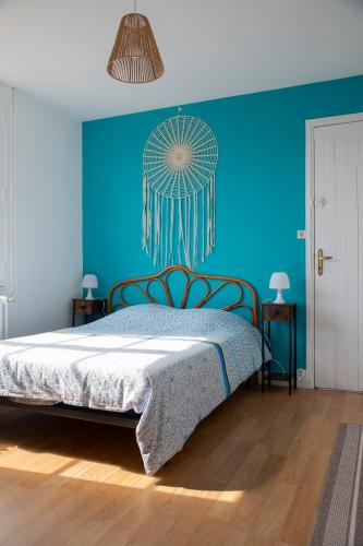 - une chambre bleue avec un lit et un mur bleu dans l'établissement Villa Anahita, à Lanton