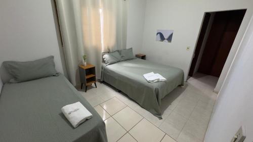 a bedroom with two beds and a door with a mirror at Casa de temporada - Custódio in Uberlândia
