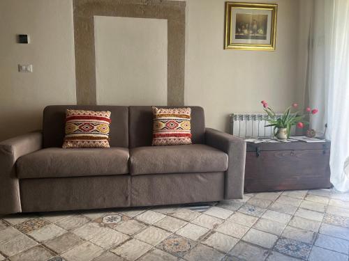a brown couch with two pillows in a living room at B&B Camelia in Camugnano