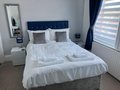 a bedroom with a large bed with white sheets and pillows at Seaview Sanctuary in Eastbourne