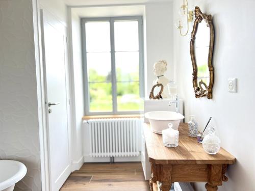 a bathroom with a wooden table and a mirror at La Résidence Périgourdine Meublé Tourisme 5 étoiles Luxe in Anlhiac