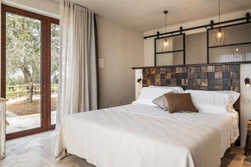 a bedroom with a large white bed and a window at Casale Oleo in Montiano