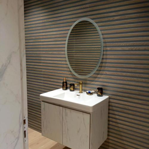 a bathroom with a sink and a mirror at Hôtel La Perla in Al Hoceïma