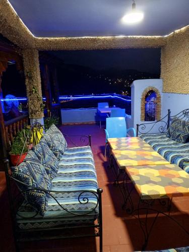 a balcony with couches and a view of a city at Dar Lbakal in Chefchaouene