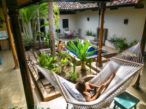 een vrouw in een hangmat op een patio bij Casa Miskitu in Granada