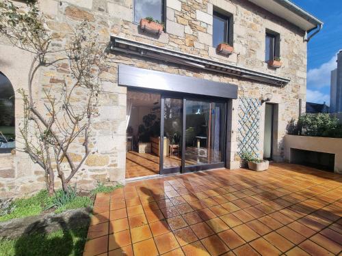 Elle offre une vue sur l'extérieur d'une maison dotée d'une terrasse. dans l'établissement Grande longère au port, à Perros-Guirec