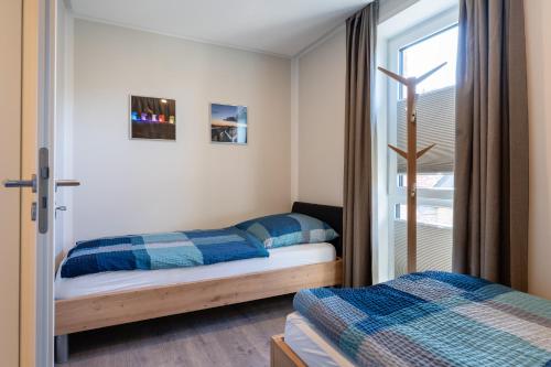 une chambre avec deux lits et une fenêtre dans l'établissement Ankerglück, à Kellenhusen