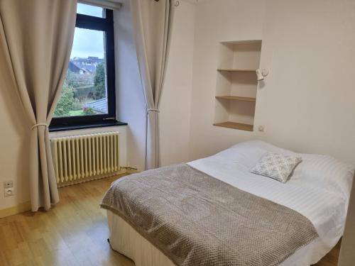 une chambre avec un lit et une grande fenêtre dans l'établissement Grande longère au port, à Perros-Guirec