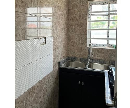 a kitchen with a sink and a glass shower at YP-Made Luxurious 1 & 2 Bedroom Apartments in Eluju