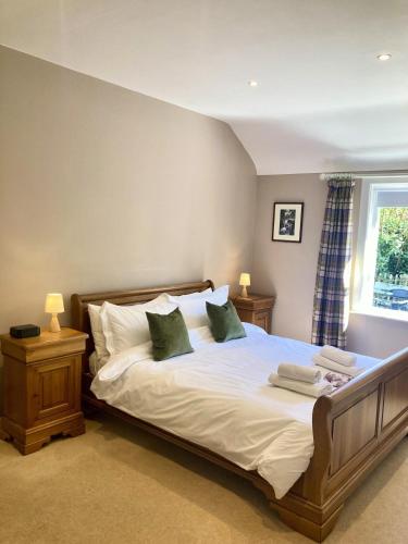a bedroom with a large bed with two lamps and a window at Curragh-Ard Cottage in Newcastle