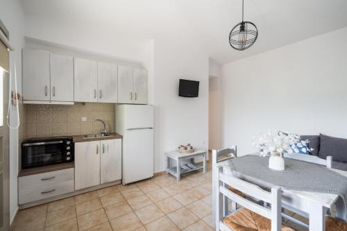 a kitchen and a dining room with a table and a kitchen at Palos Studios in Livadion