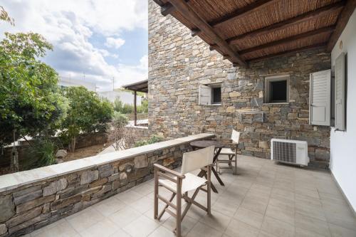 a patio with chairs and a stone wall at Palos Studios in Livadion