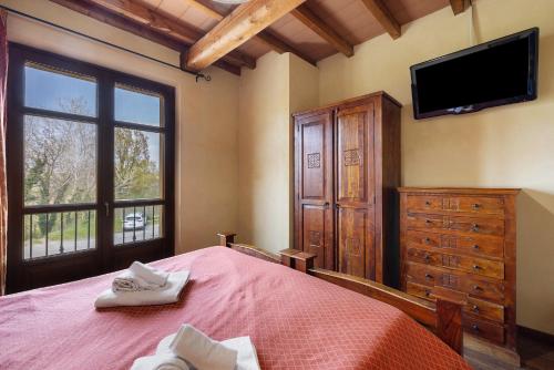 a bedroom with a bed and a tv and a dresser at Fattoria Delle Vignole in Sommariva Perno