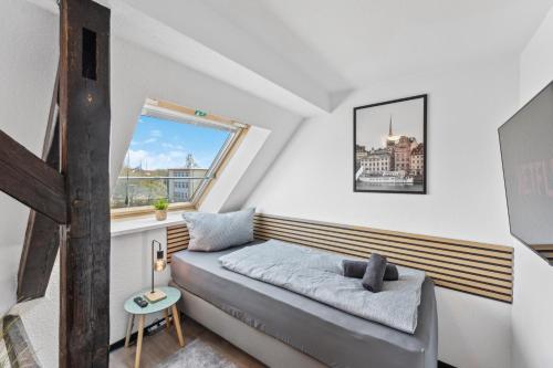 a small bedroom with a bed and a window at Larooms - Naumi#1 in Merseburg