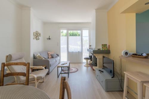 un salon avec un canapé et une télévision dans l'établissement La Gilda - 350m de la mer - Wifi, à Préfailles