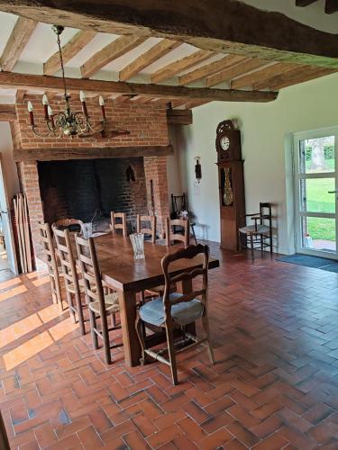 une salle à manger avec une table, des chaises et une horloge dans l'établissement Retour a la campagne 12, à Lamberville