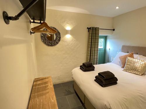 une chambre avec un lit avec deux serviettes dessus dans l'établissement Preseli Hills Cottages - Luxury 5 star Cottages in Pembrokeshire, à Mynachlogddu