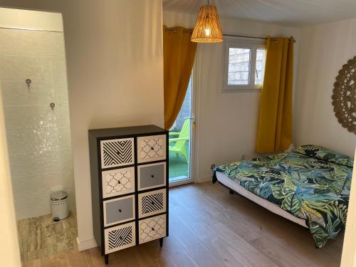 une chambre avec un lit, une commode et une fenêtre dans l'établissement Joli rez de jardin 3 pieces à Cagnes sur mer, à Cagnes-sur-Mer