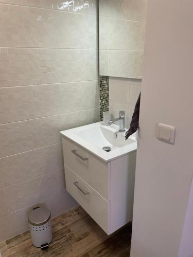 une salle de bain blanche avec un lavabo et un miroir dans l'établissement Joli rez de jardin 3 pieces à Cagnes sur mer, à Cagnes-sur-Mer