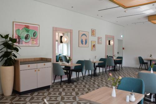 a restaurant with tables and chairs in a room at Garner Hotel Essen - Handelshof by IHG in Essen
