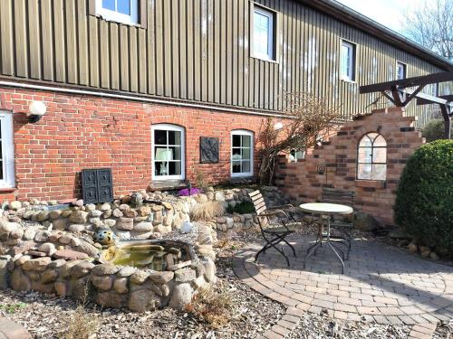 a brick building with a table and chairs in a yard at Hilde - gemütliche und moderne FeWo bei der Porzellanbörse in Handewitt