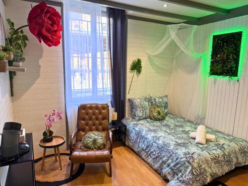 une chambre avec un lit et une chaise dedans dans l'établissement Pitchoune - Centre -Wifi - Equipé, à Dax