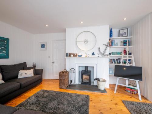 a living room with a couch and a fireplace at The Bolthole in Kingsbridge
