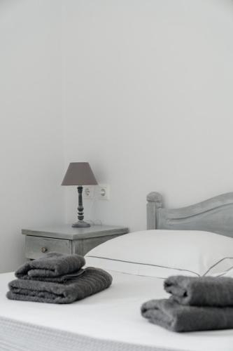 a bed with a table with a lamp on it at Palos Studios in Livadion