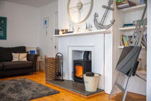 a living room with a fireplace and a tv at The Bolthole in Kingsbridge