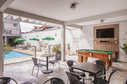 a patio with a pool table and chairs at Hotel Nacional Inn Araçatuba in Araçatuba