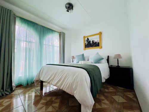 a bedroom with a bed and a large window at Palm Haven 5 min drive to Carlswald Centre in Midrand