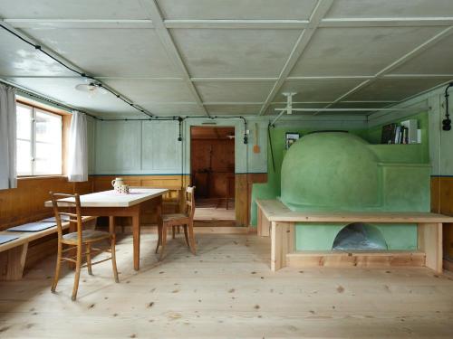 a dining room with a table and a green room at Floras Haus Hostel in Schattwald