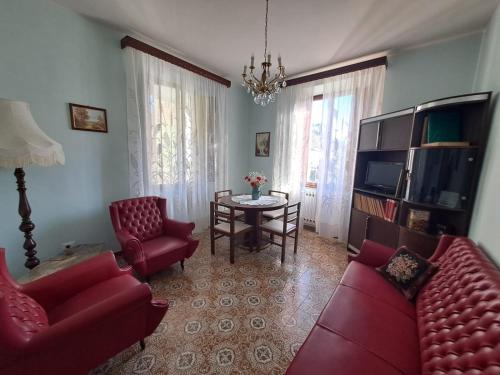 a living room with two red couches and a table at Casa vacanze Rosa in Barga