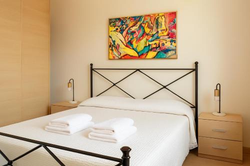 a bedroom with a white bed with two towels on it at Casa Del Mare 50 m dal mare - nuova - Pasqua in Maremma in Castiglione della Pescaia