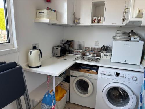 a kitchen with a washer and dryer on a counter at Eildon in Menai Bridge