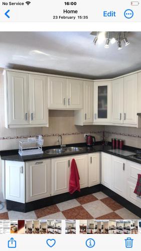 a kitchen with white cabinets and black counter tops at Large 1 bed apartment in the beautiful countryside in Rute