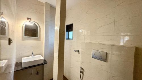 a bathroom with a sink and a shower at Hotel Dwani Palace in Navi Mumbai