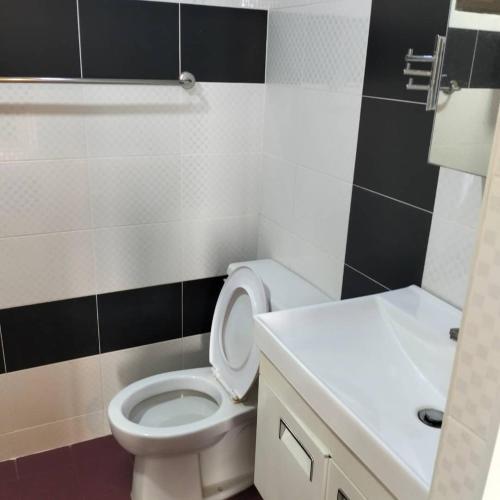 a bathroom with a white toilet and a sink at Sri sayang pearl view in Batu Ferringhi