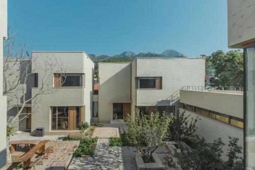 an external view of two buildings with a courtyard at The Long Circle House in Yanqing