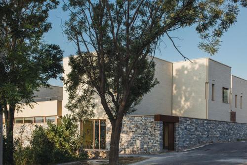 a house with a tree in front of a building at The Long Circle House in Yanqing