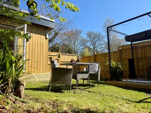 a patio with a table and chairs in a yard at Acorn Lodge Pentewan in St Austell