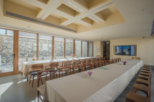 a large room with tables and chairs and windows at The Long Circle House in Yanqing