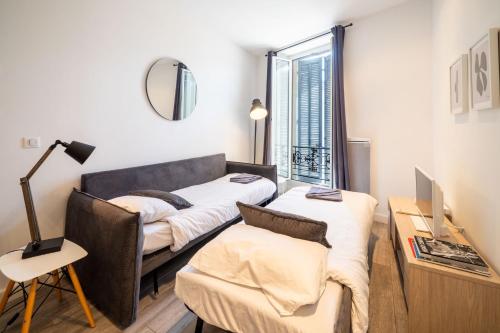 un salon avec un canapé et une chaise dans l'établissement Le refuge du Suquet, quartier authentique de Cannes, vue mer, à Cannes